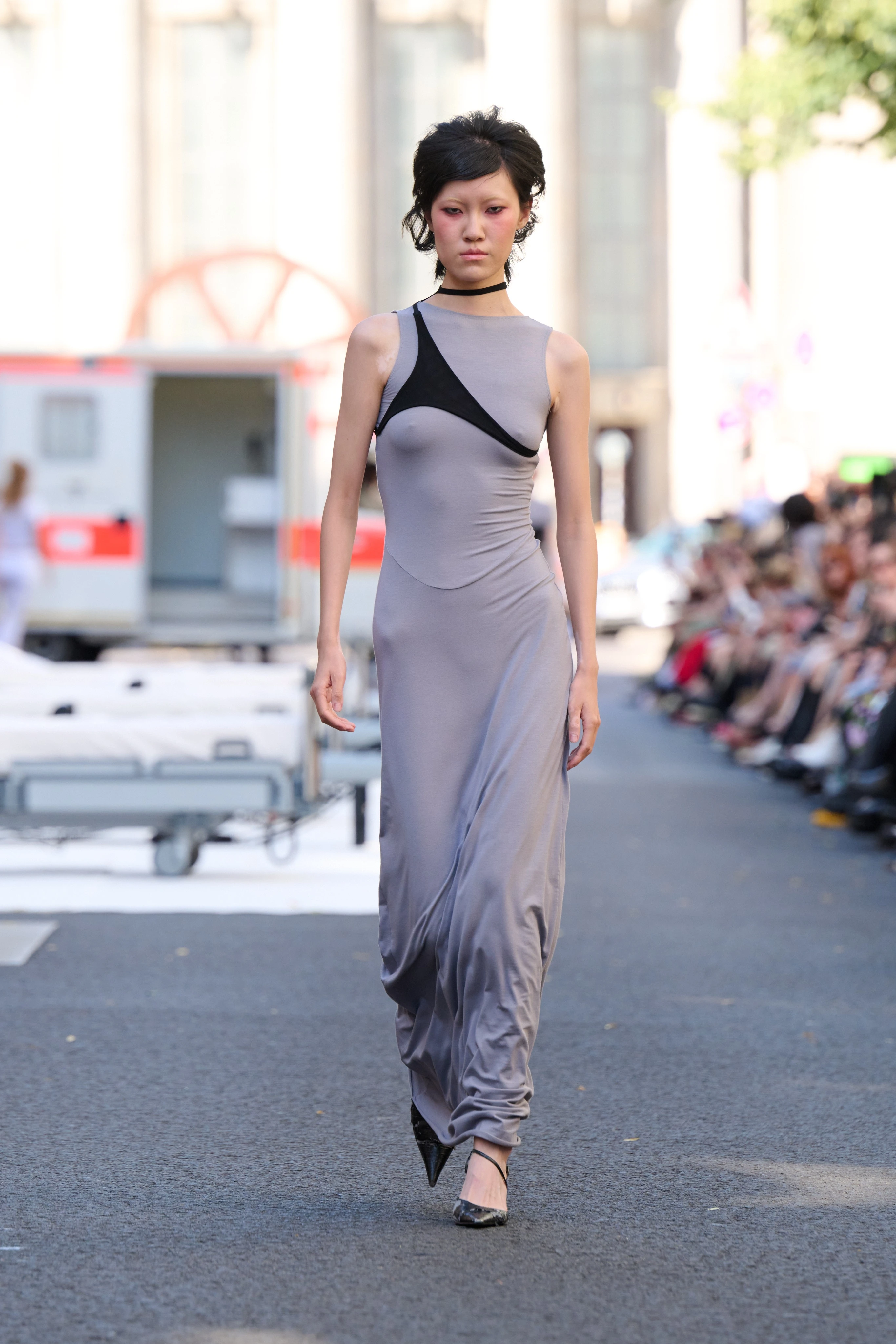 Gray floor-length dress with asymmetrical black line across the chest from Clara Colette Miramon SS26 collection at Berlin Fashion Week worn by a model.