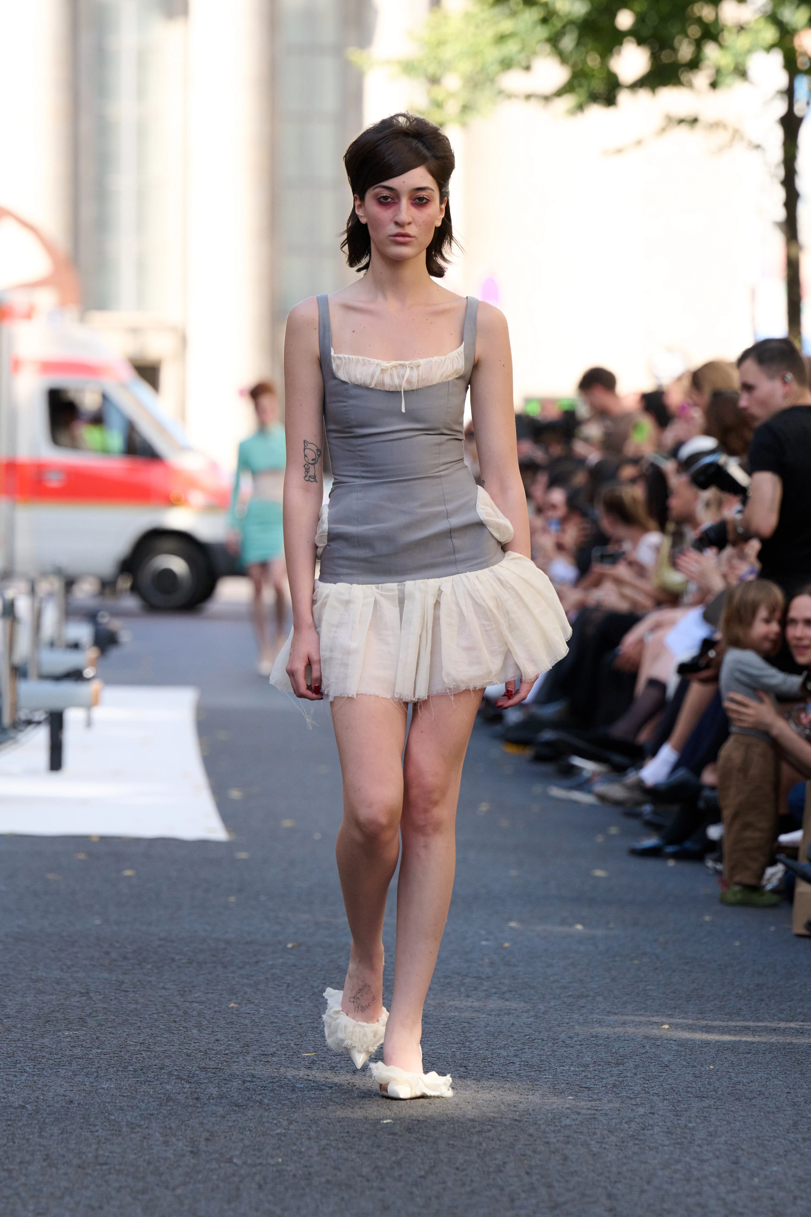 Gray dress with white ruffles at the cleavage and on the seam from Clara Colette Miramon SS26 collection at Berlin Fashion Week worn by a model.