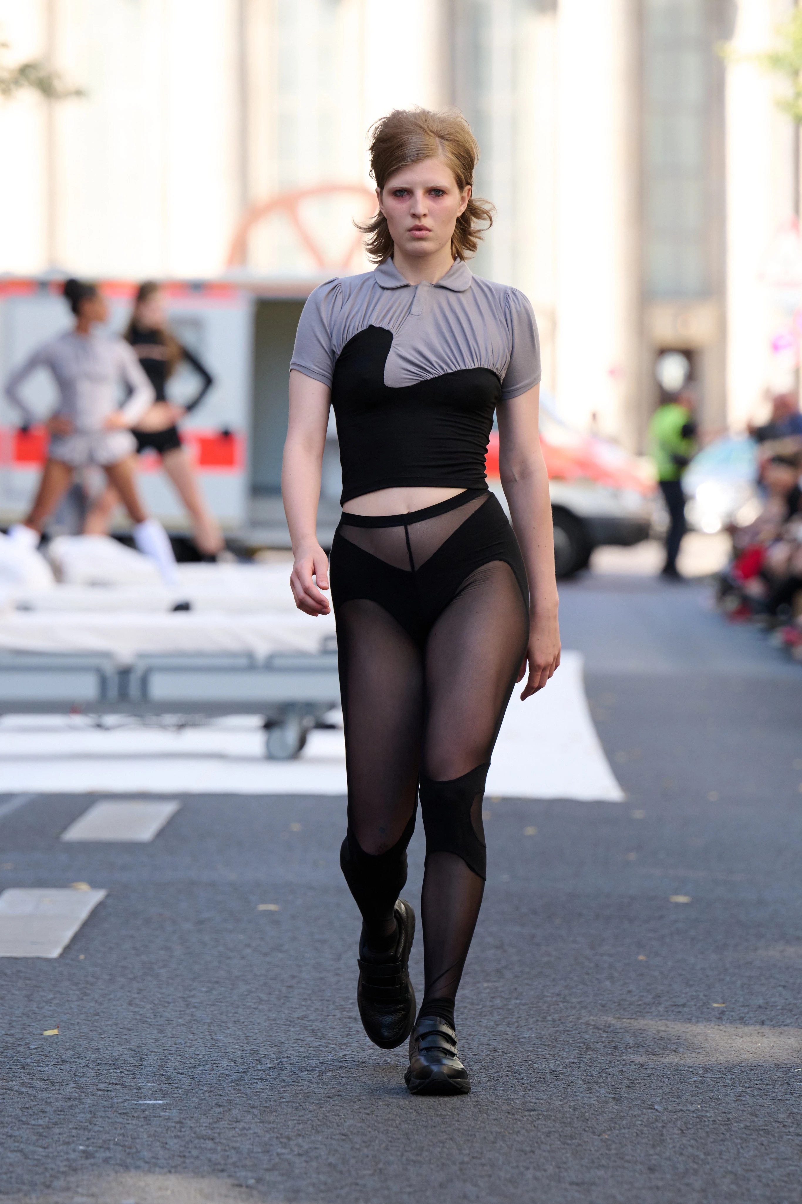 Gray asymmetrical shirt and black see-through tights from Clara Colette Miramon SS26 collection at Berlin Fashion Week worn by a model.